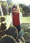 Another view of Anna, leaning over a cactus.