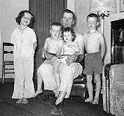 Dad holding Dick and me while Mary and John stand next to him.