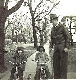 Our father watching over Mary and John outside with their tricycles.